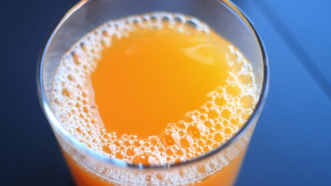 Succo d'arancia fresco con bolle in un bicchiere