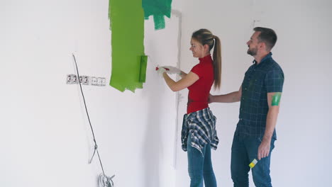 man-kisses-girlfriend-painting-wall-with-green-in-room-2
