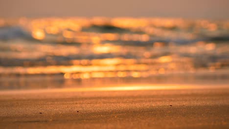 zoom in sea wave and sand beach on the evening with blurred and bokeh background