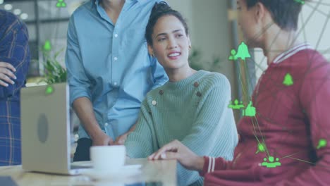 Animation-of-globes-of-digital-icons-spinning-over-diverse-colleagues-discussing-together-at-office