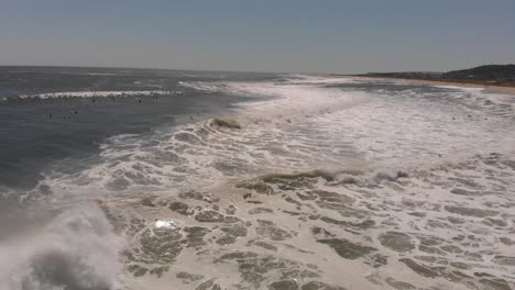 surfers in the lineup of breaking waves, editorial