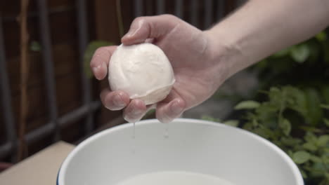 soaked mozzarella cheese, squeezed by hand. slow motion