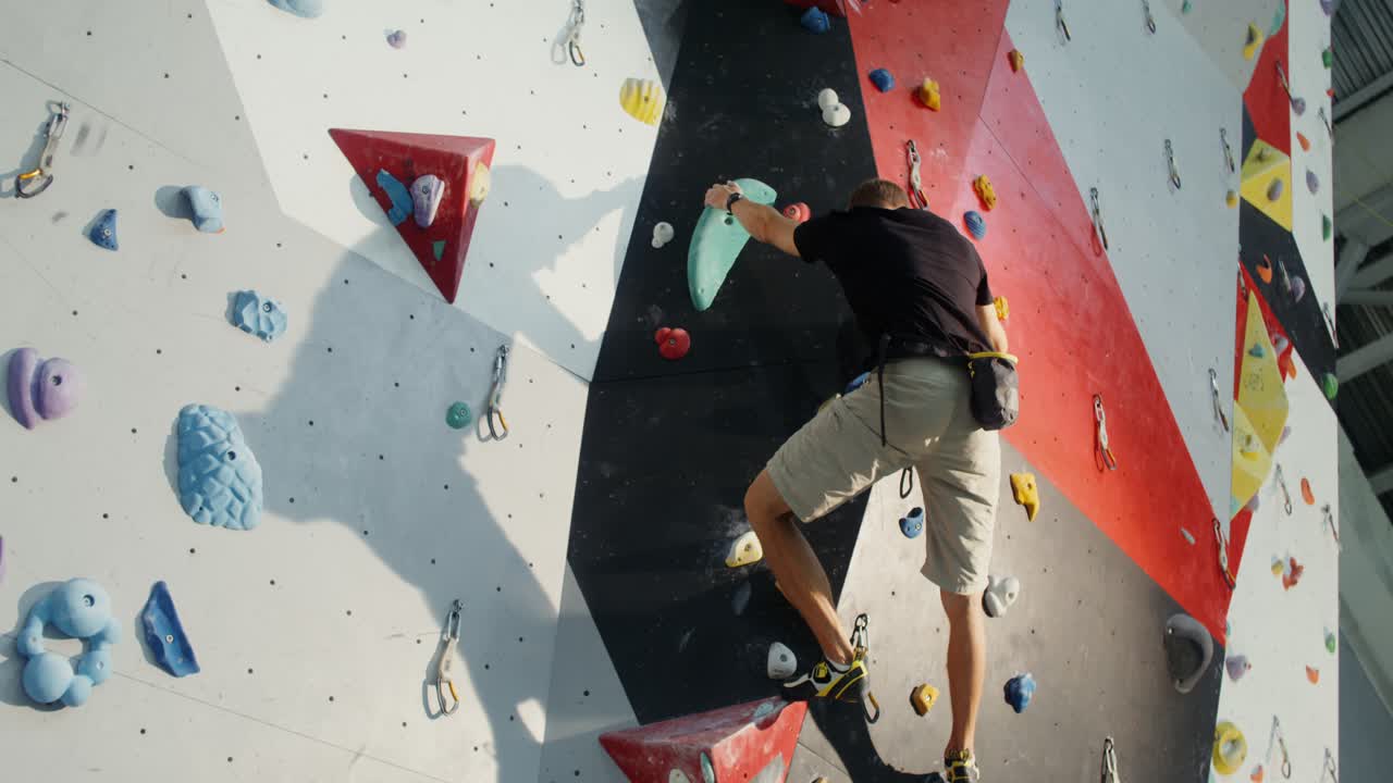 hombre bouldering en la pared de escalada