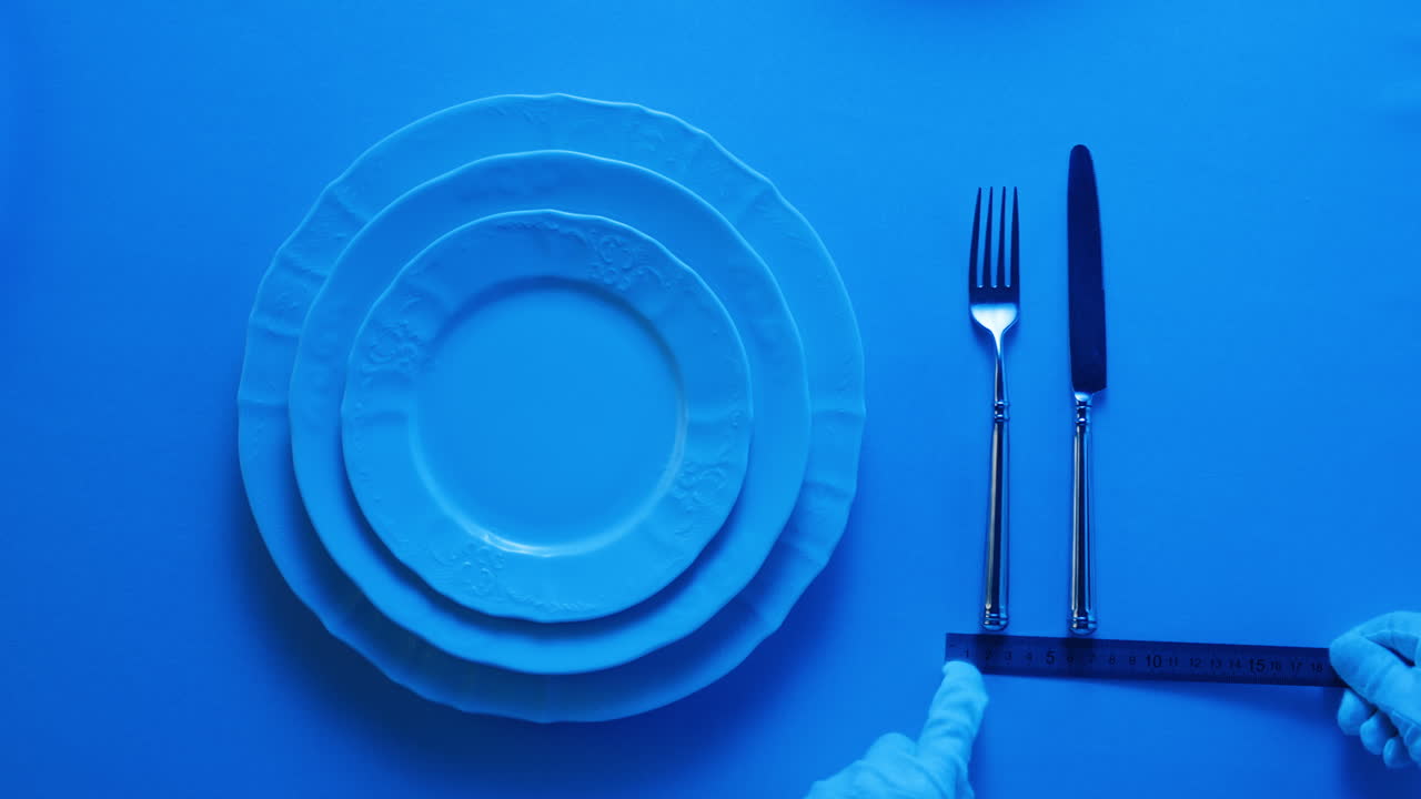 Elegant table setting with white tableware plates, cutlery, and glassware for a classy dining, fancy expensive restaurant dinner