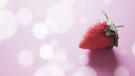 composition of strawberry and white spots on pink background