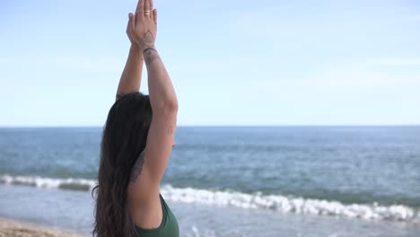 Woman practicing yoga on beach with ocean view
