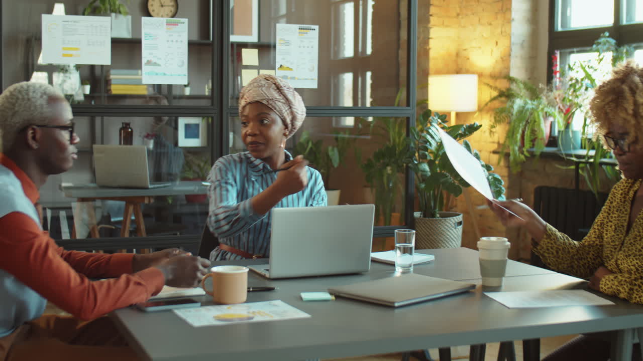 African American Businesswoman Talking with Team at Office Meeting