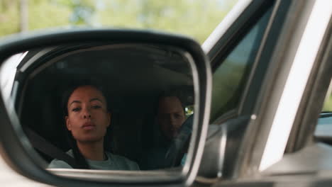 woman adjusting rear mirror