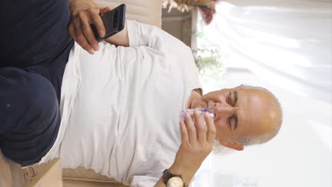 Vertical-video-of-The-old-man-who-drinks-water-at-regular-intervals.-The-old-man-seeks-healing.