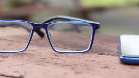 blue  eyeglass and smart phone on table ,