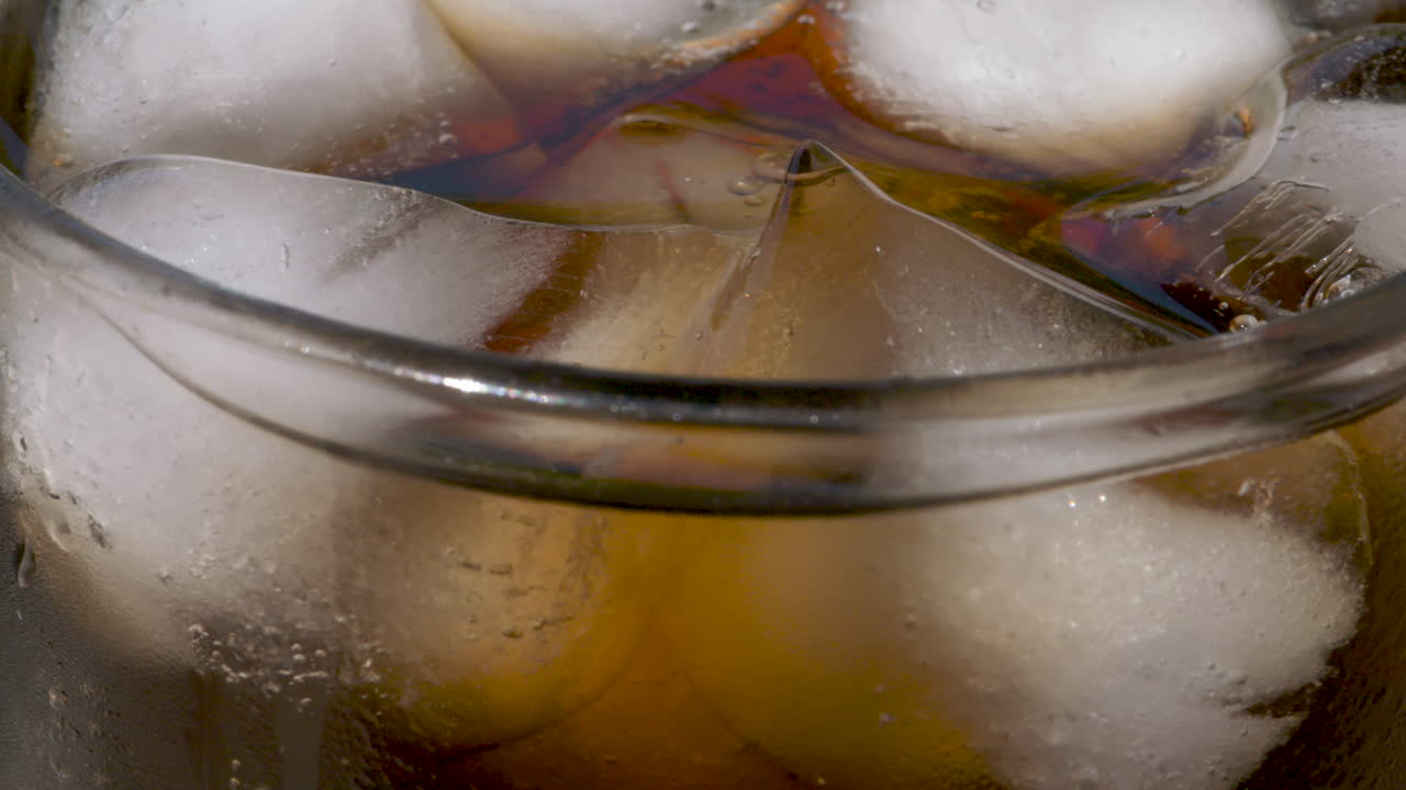 macro de cámara lenta de cerca, refrescante vaso de hielo y cola