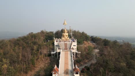 aerial view of wat phra that doi kham temple with golden buddha statue on a mountain