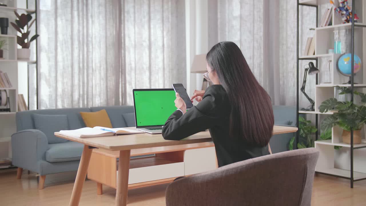 노트북과 스마트폰으로 집에서 일하는 여성