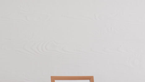 wooden frame with copy space on white background and white wall