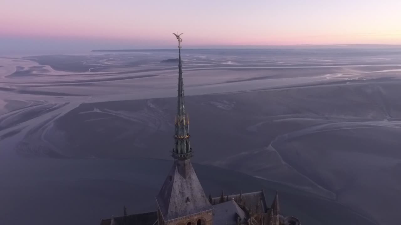 estatua de san miguel en la aguja del monte san miguel abadía torre con bahía en el fondo al atardecer