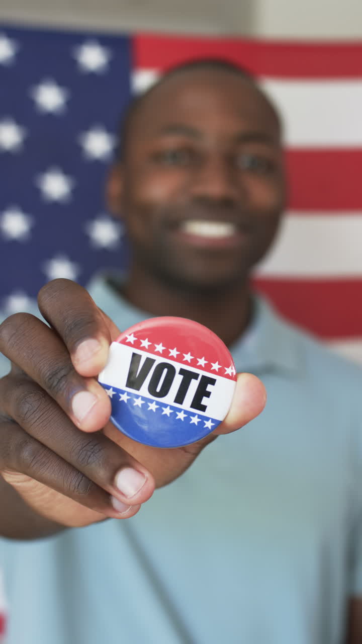Vertical video: Holding Vote button, man smiling in front of American flag