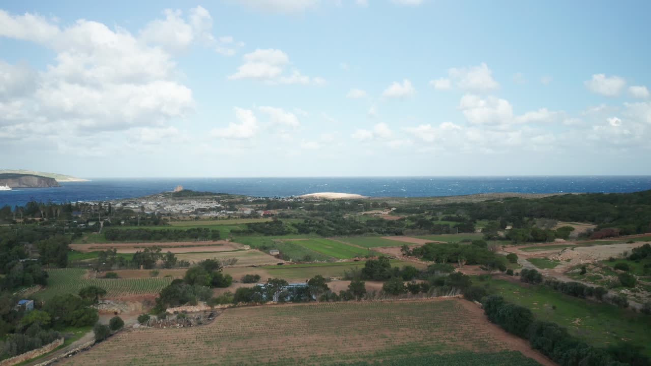 항공: 마을을 배경으로 코미노 섬과 농지의 일부를 드러냄