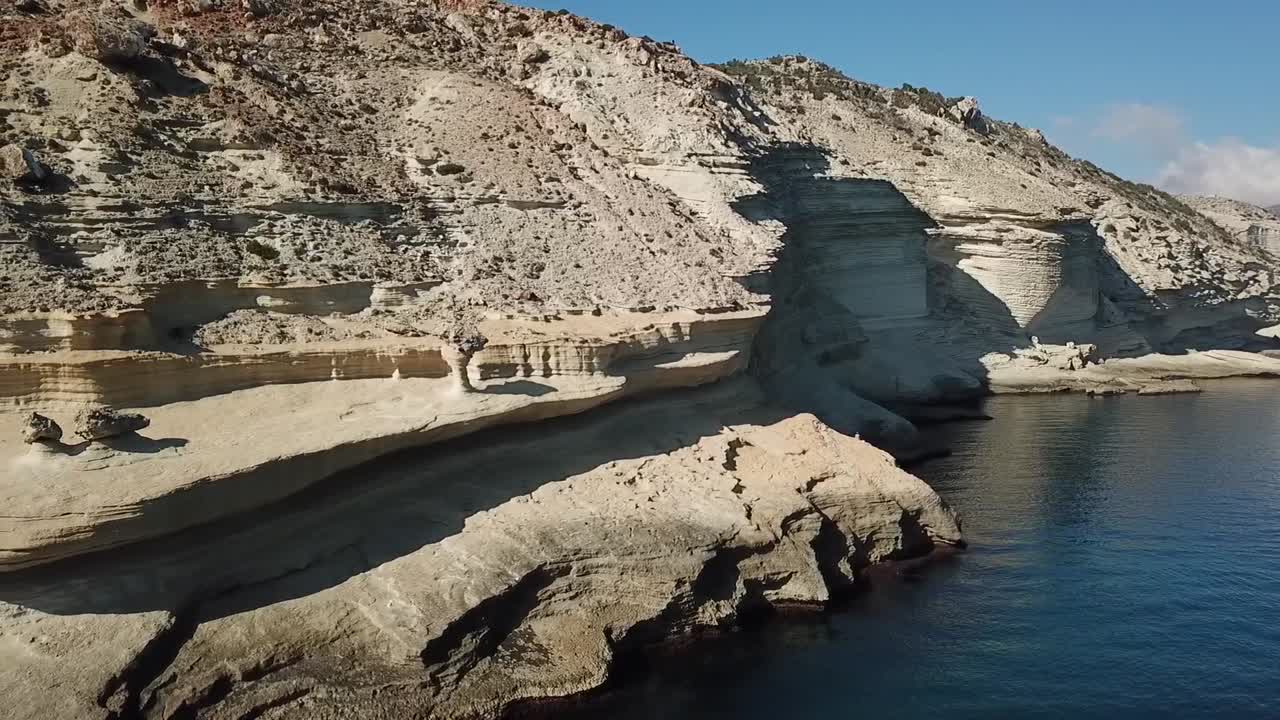 Drone shot flying over rugged white cliffs along the Nador coastline, contrasting with clear turquoise Mediterranean waters