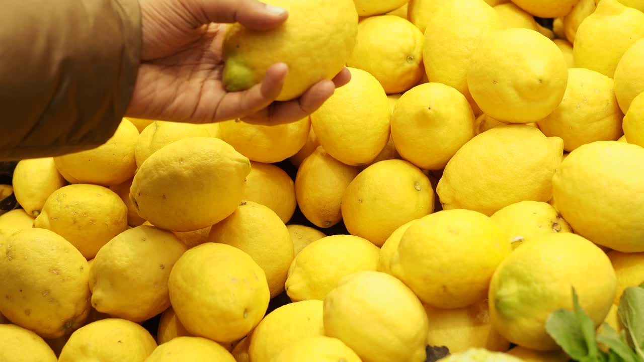 Person selecting lemons at a market