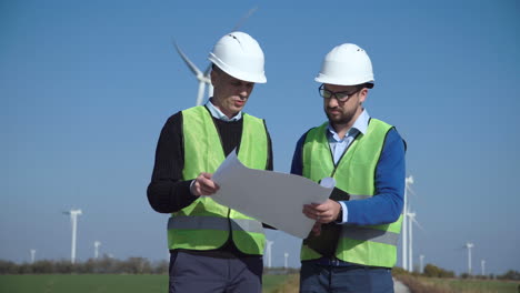 engineers reviewing plans at a wind farm