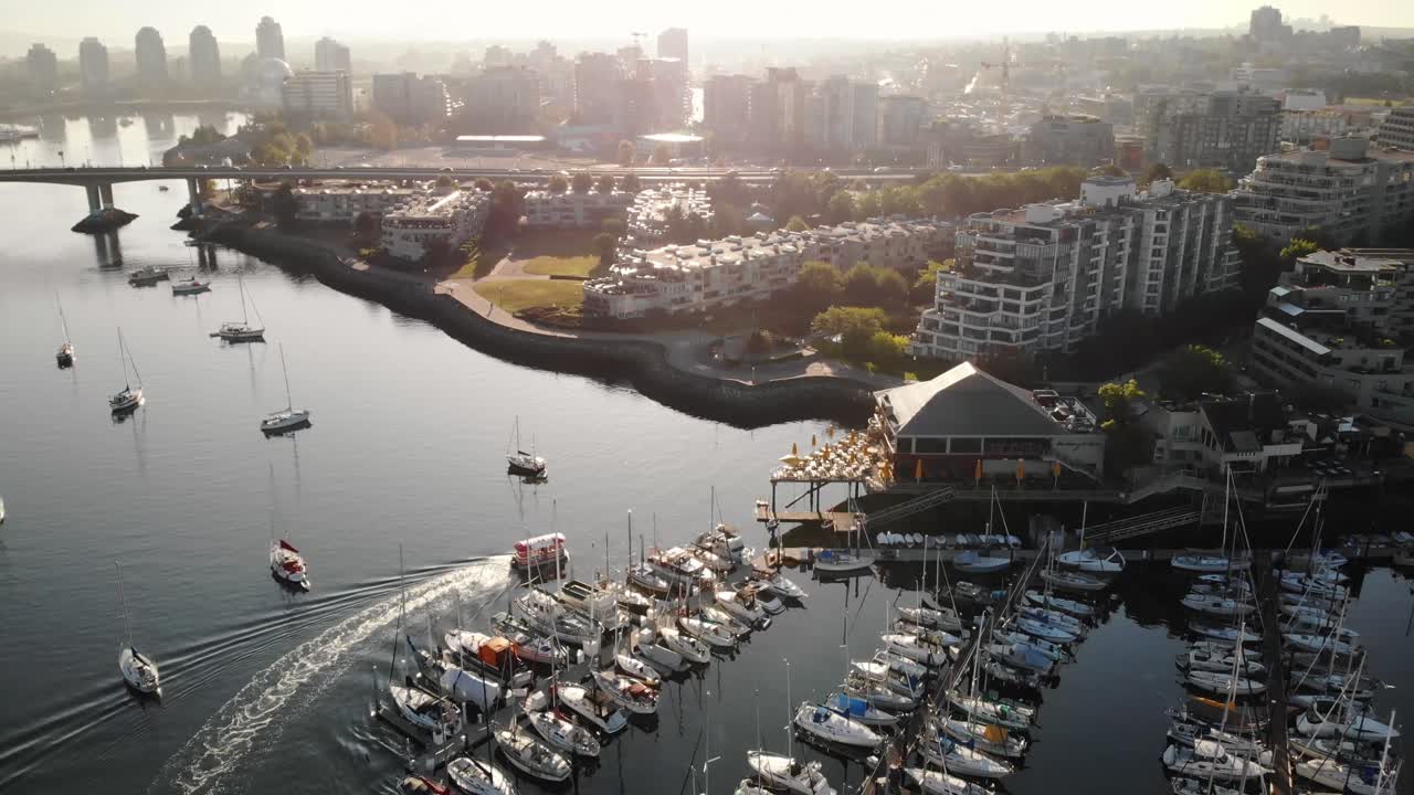 Stunning Aerial Footage of Marina and Canadian Boat, panning into the city landscape of Vancouver, Canada. Beautiful lens flares and dynamic composition in 4K.