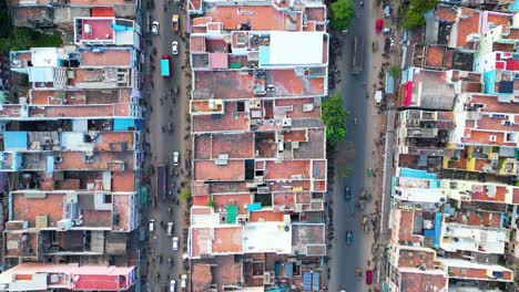 Crowded-street-with-compact-home-buildings-built-up-with-traffic-motorbikes-and-cars-flowing-on-roads