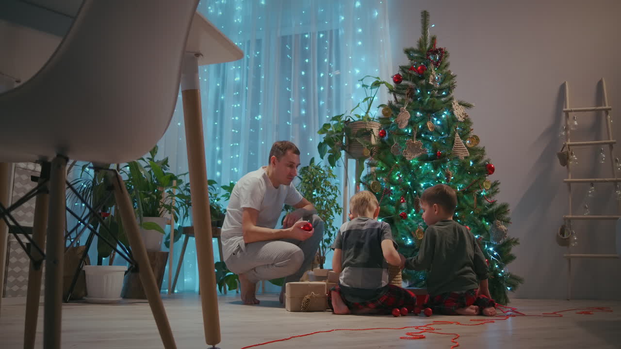 samya padre y dos hijos juntos decoran el árbol de navidad para el año nuevo y navidad. decoraciones de año nuevo. imágenes de alta calidad 4k