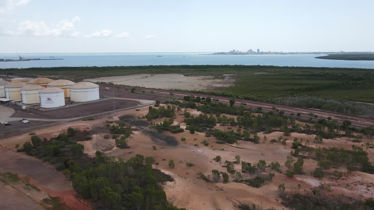 tiro aéreo descendente de drones del área industrial del brazo este y almacenamiento de petróleo con el horizonte de darwin, territorio del norte