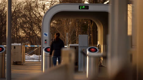 person walking through a modern transit gate or turnstile