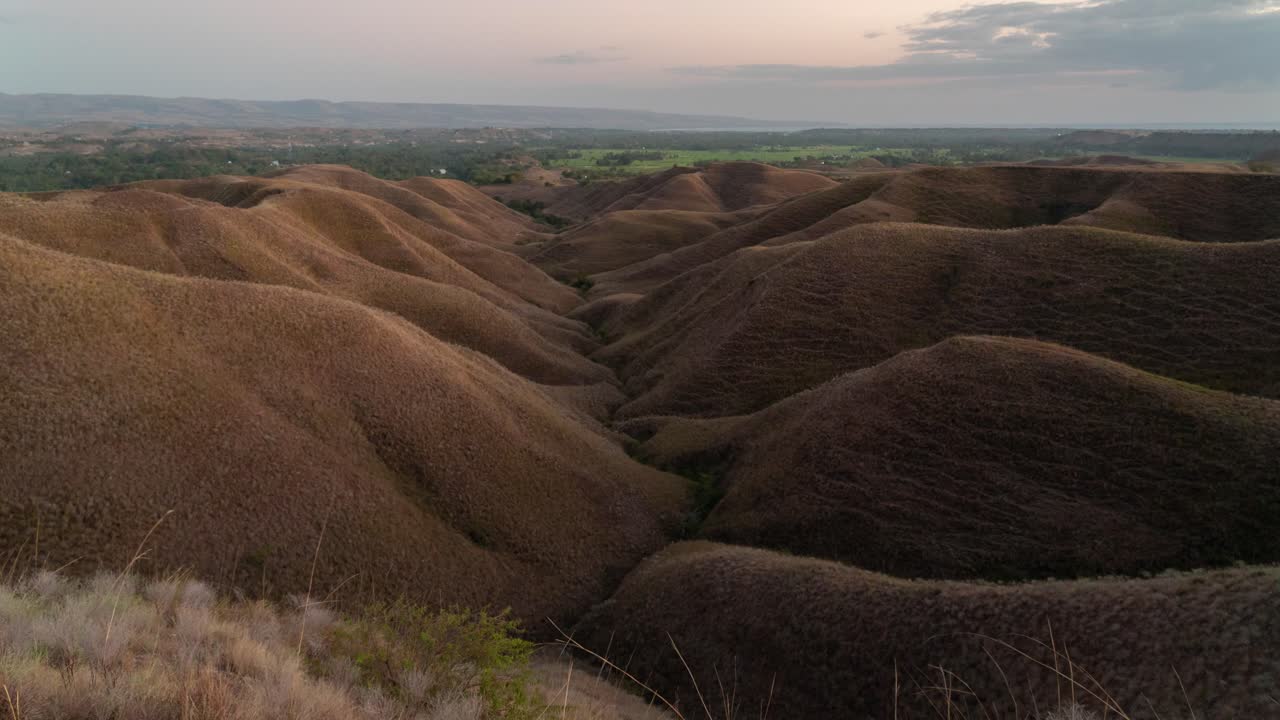Panoramic view of rolling hills and dry savanna landscape at dusk