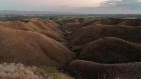 panoramic view of rolling hills and dry savanna landscape at dusk