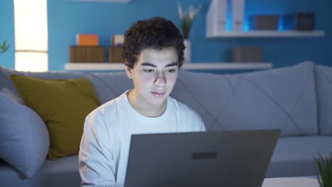 hombre adolescente feliz y considerado y guapo usando una computadora portátil.