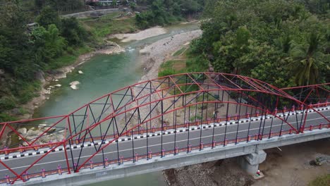 beautiful aerial view of a bridge over a river nestled between mountains