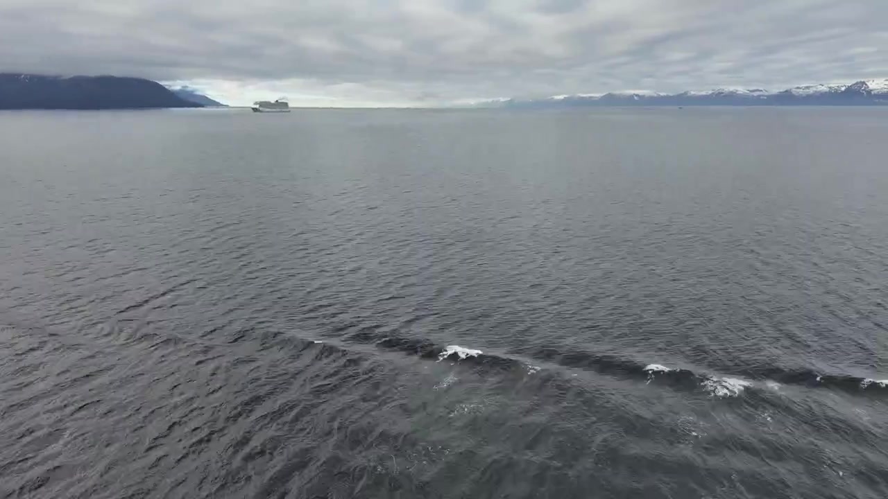 timelapse of Alaskan sky and calm ocean with a cruise ship appearing, passing by