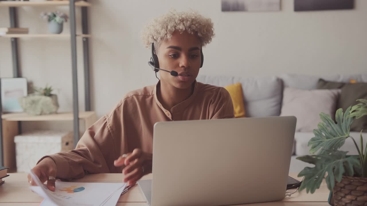 Afro woman wear headset talking with client online