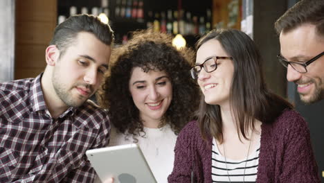 friends sharing tablets and drinks in a