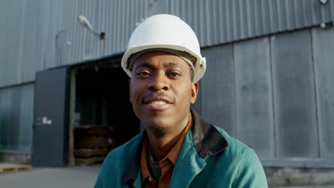 smiling factory worker in front of warehouse
