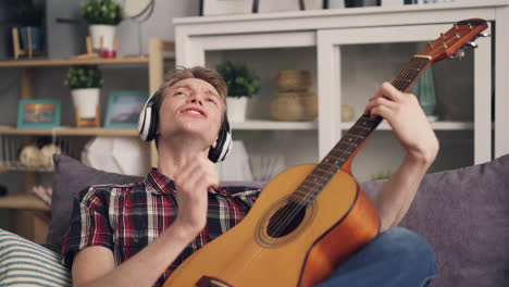 man playing guitar and singing at home