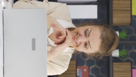 vídeo vertical de una mujer de negocios viendo buenos resultados en una computadora portátil.