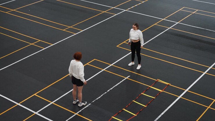 Players train with shuttle and ladder. Two athletes practicing rapid rally drills and agility. Pair of sportspeople engaged in fastpaced shuttle exchanges emphasizing timing and agility exercises