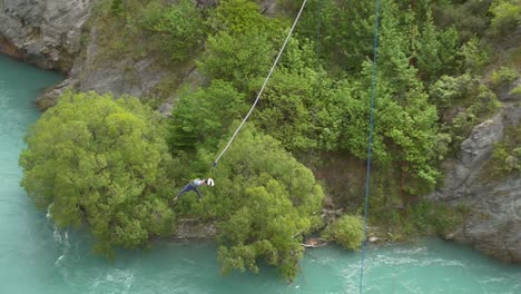 man bungee jumping over river