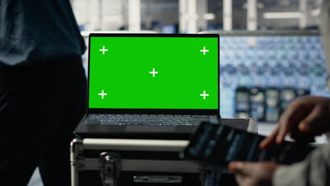 data center technician monitors deep learning process with green screen laptop