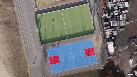 Top-down-aerial-of-two-multifunctional-sport-fields-in-Hafnarfjordur,-Iceland