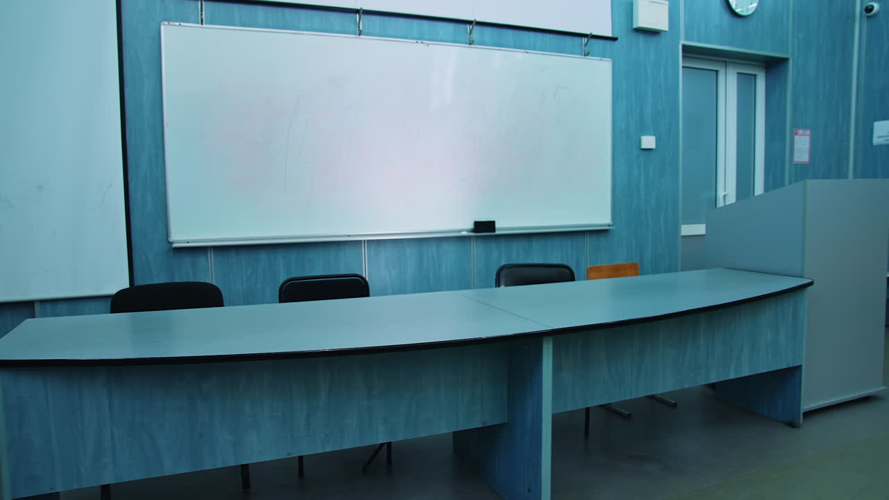 Presidium place with modern equipment. Auditorium with a blackboard, white board and teacher's table. Beautiful empty classroom in blue colors.