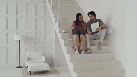 colegas trabajando en las escaleras de una oficina minimalista