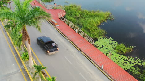 aerial-top-down-view-of-truck-driving-on-empty-road-near-Laguna-Coba-at-sunset-in-Quintana-Roo-Mexico