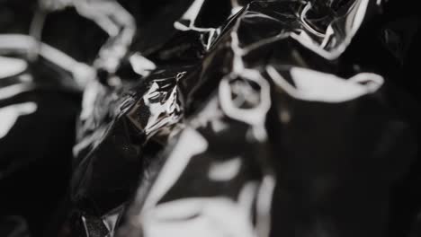 close up of black crumpled plastic rubbish bag in slow motion