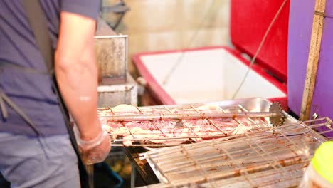 vendor grilling pork skewers at floating market