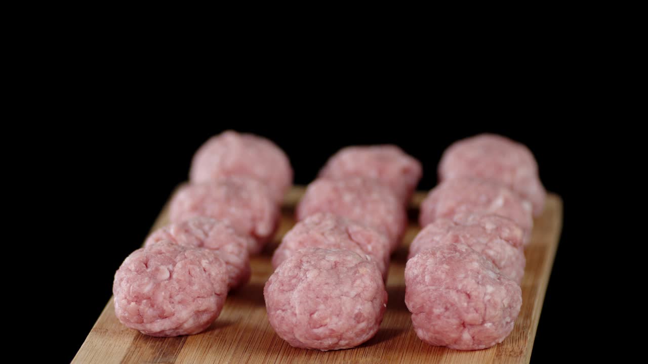 나무로 만든 절단판 위에 있는 생 고기 어리는 천천히 회전합니다.