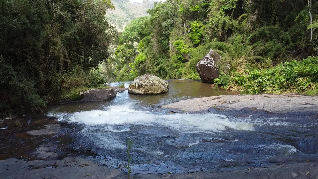 Movimento della telecamera frontale con drone che riprende la discesa ravvicinata di una splendida cascata, acque che scorrono, risalendo